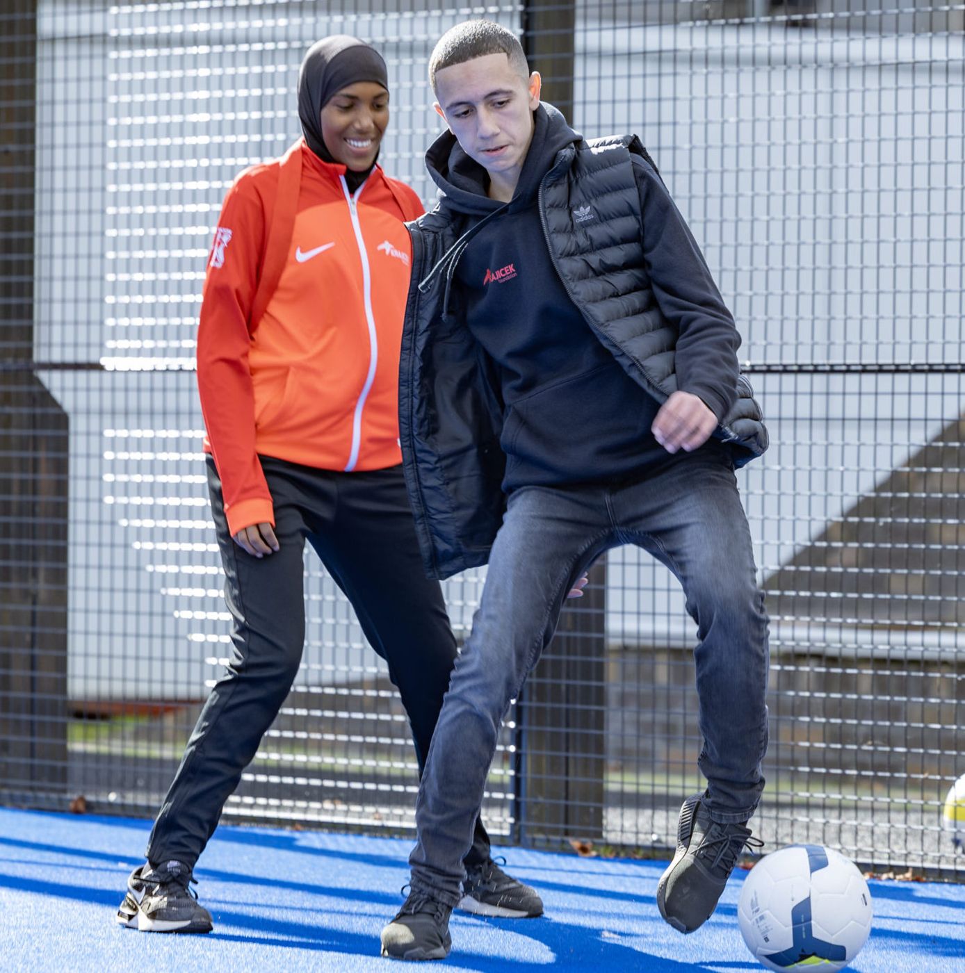 Coaches van Zawadi Sport met een voetbal op een Cruyff Court